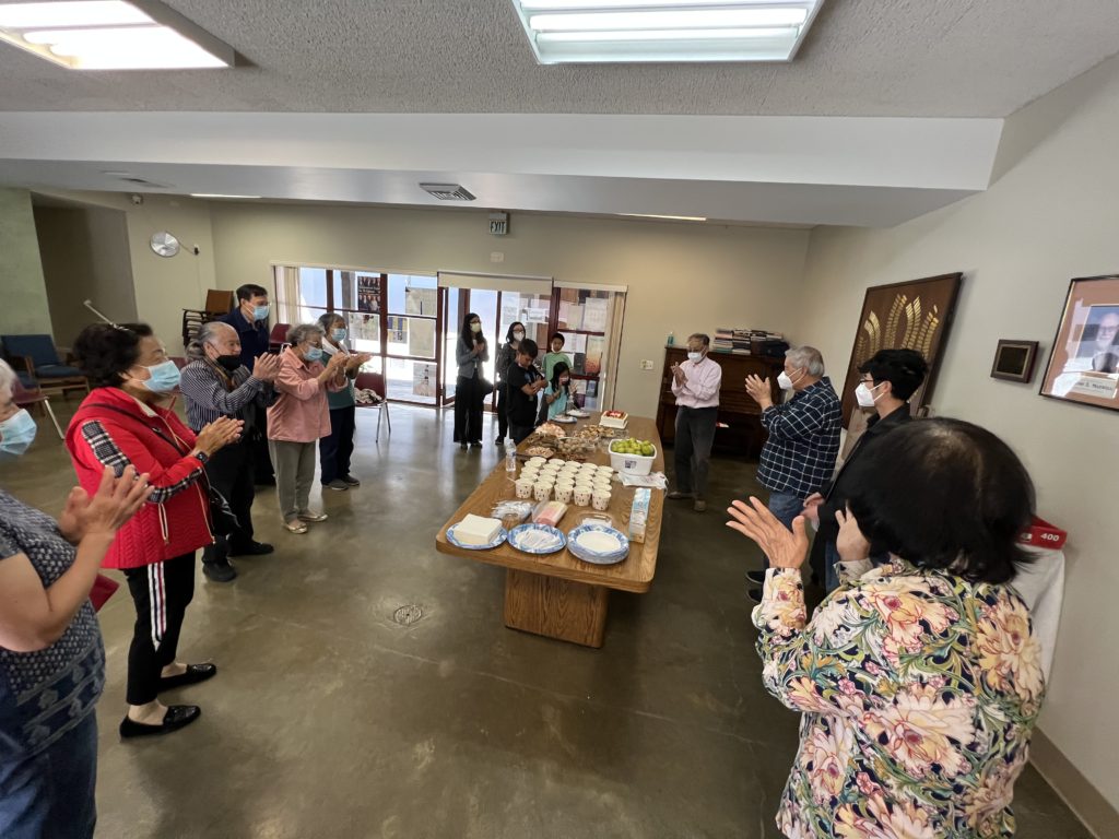 A group of people standing in a room

AI-generated content may be incorrect.